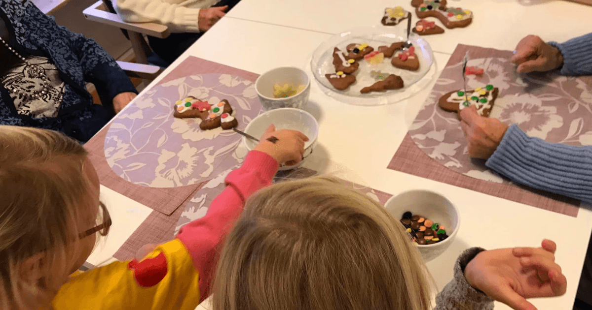 Barn og eldre pynter pepperkaker sammen